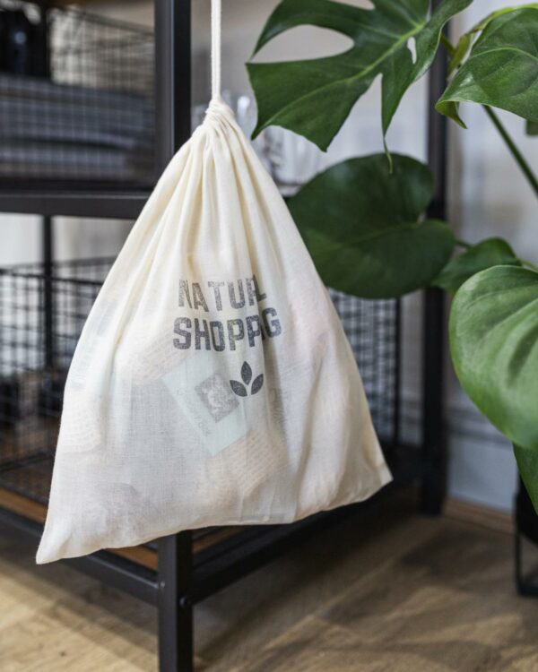 Natural shopping starter kit drawstring bag hanging by plant